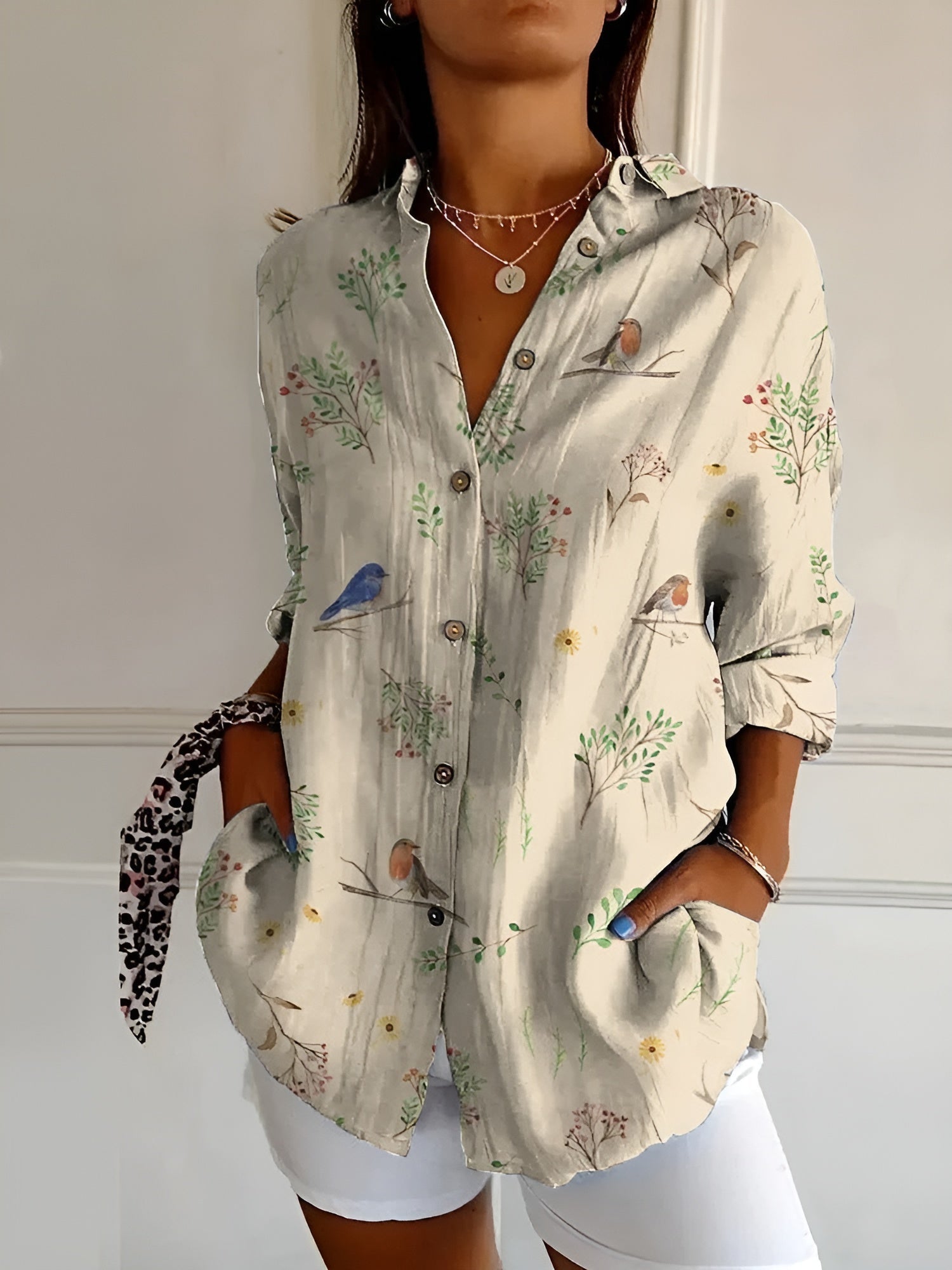 Women’s printed split-neck blouse with button front, rolled-up long sleeves; light base with bird motifs