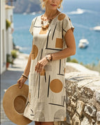 Beige shift mini dress with round neck, short sleeves, abstract geometric print