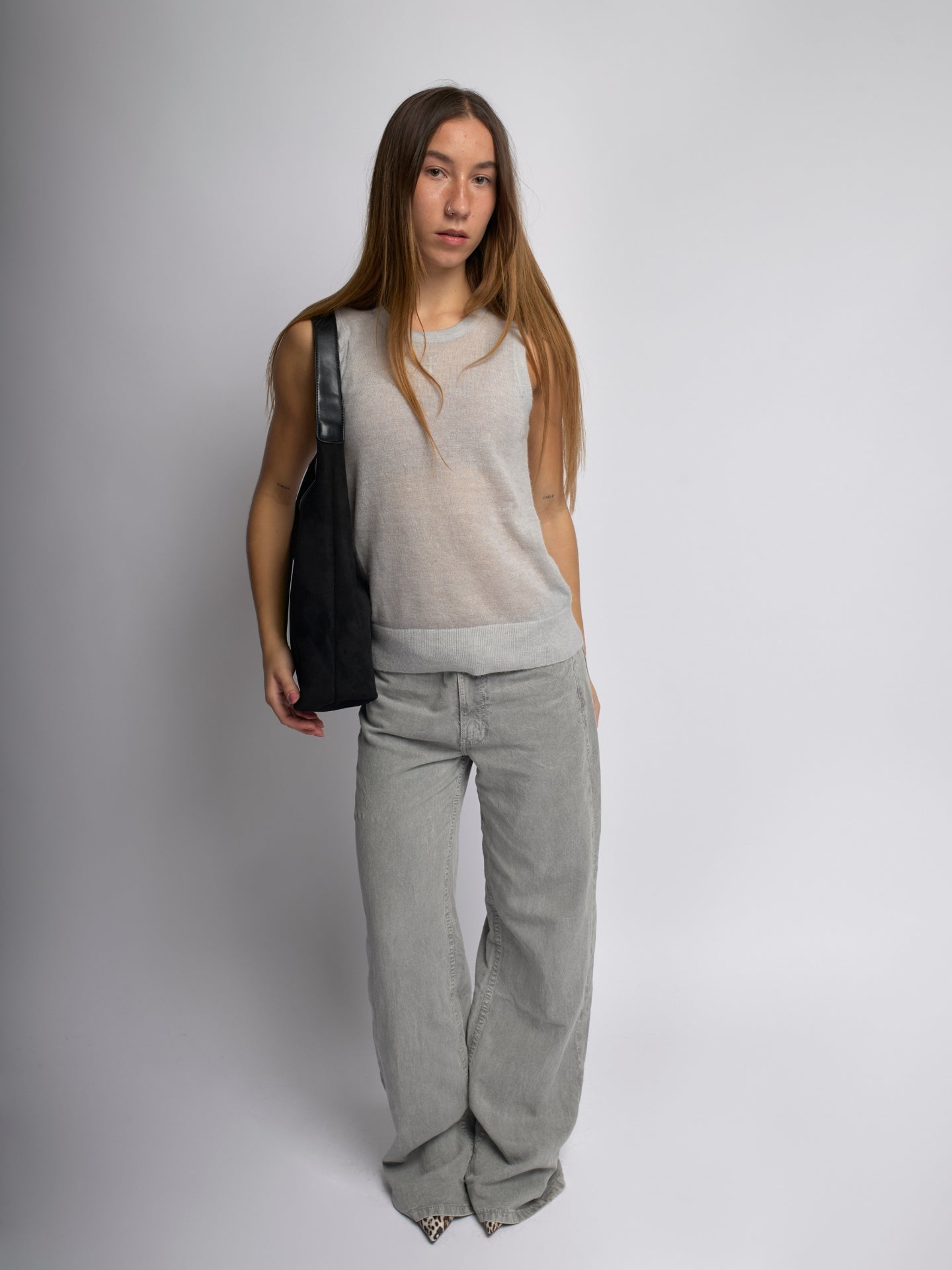 Black shoulder bag on model with curved handle and top zipper opening