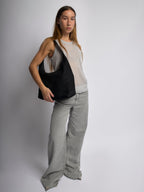 Black shoulder bag worn on shoulder with top zipper and curved handle