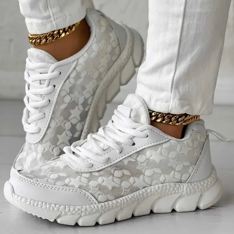 Pair of women’s white lace-up sneakers with patterned upper and padded platform sole
