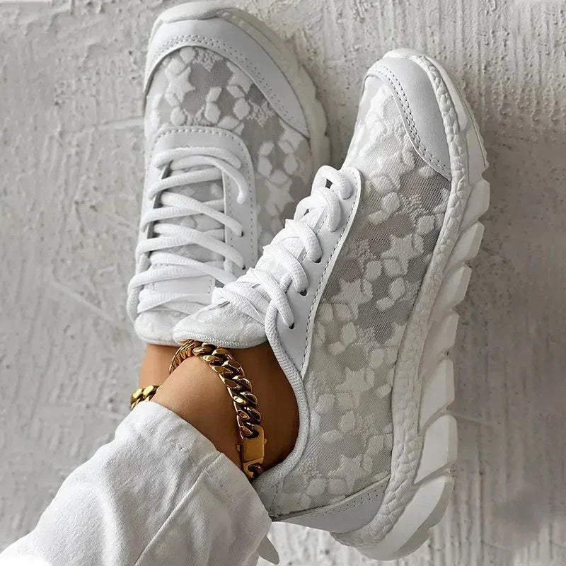 Women’s white lace-up sneakers with textured pattern upper and raised rubber sole