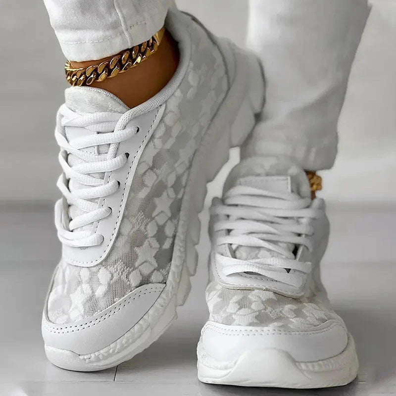 Women’s white lace-up sneakers with patterned upper and thick sole cushioning