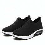 Black slip-on cushioned sneakers with textured upper and white sole