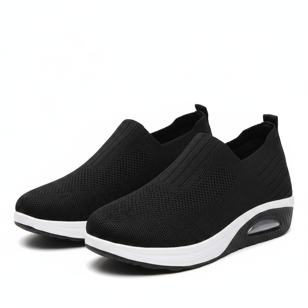 Black slip-on cushioned sneakers with textured upper and white sole