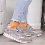 Gray zip-front women's sneakers with lace-up, textured panels, and silver accents.