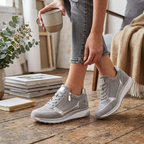 Grey zip-up knit sneakers on feet with white cushioned soles
