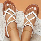 White open-toe flat sandals, crisscross straps, braided toe loops, gold ankle chain