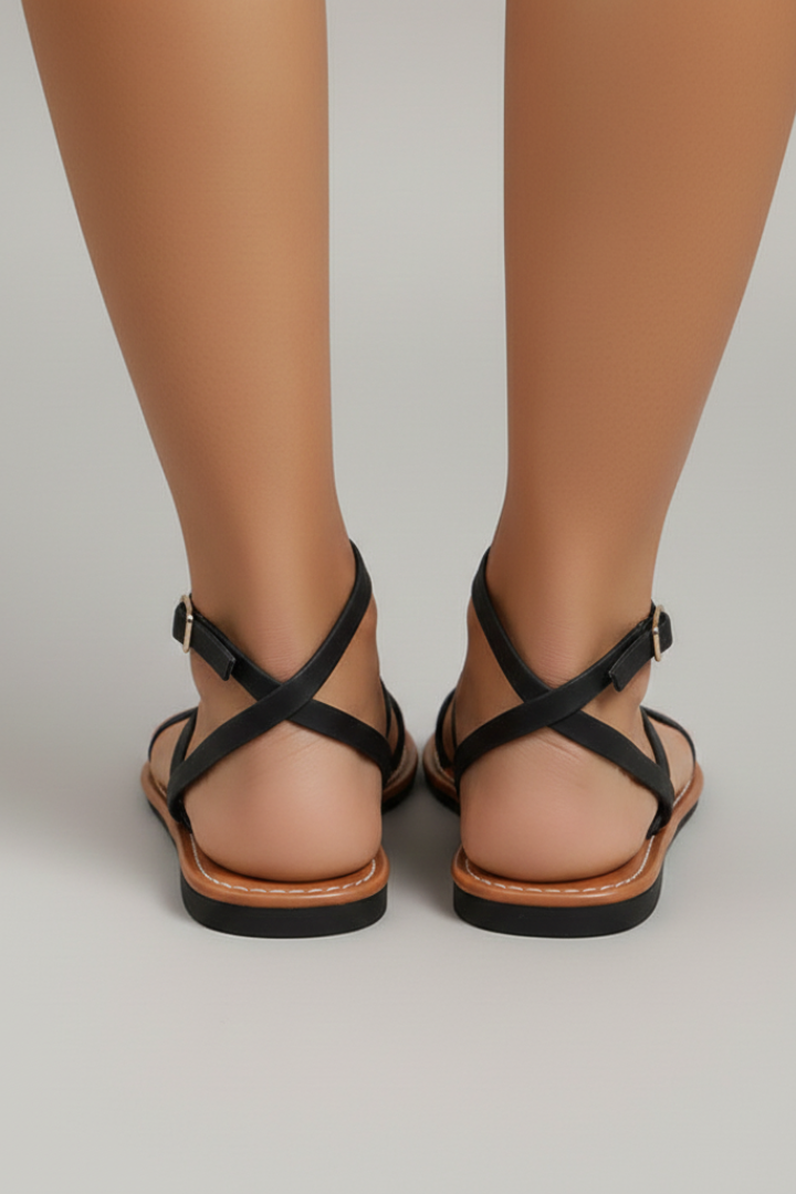 Women's black flat sandals with ankle strap buckle and criss-cross back straps, open toe