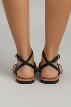 Women's black flat sandals with ankle strap buckle and criss-cross back straps, open toe