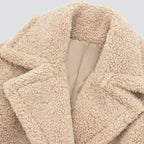 Beige sherpa faux-fur teddy coat fabric close-up with inner lining