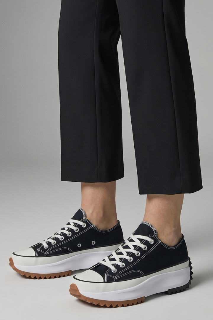 Women’s black trainers with brown tread leather platform sole, angled close-up