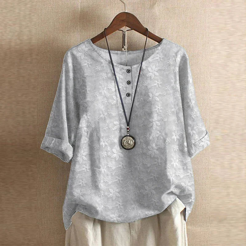 Women’s light grey blouse with subtle floral texture, short sleeves, round neck