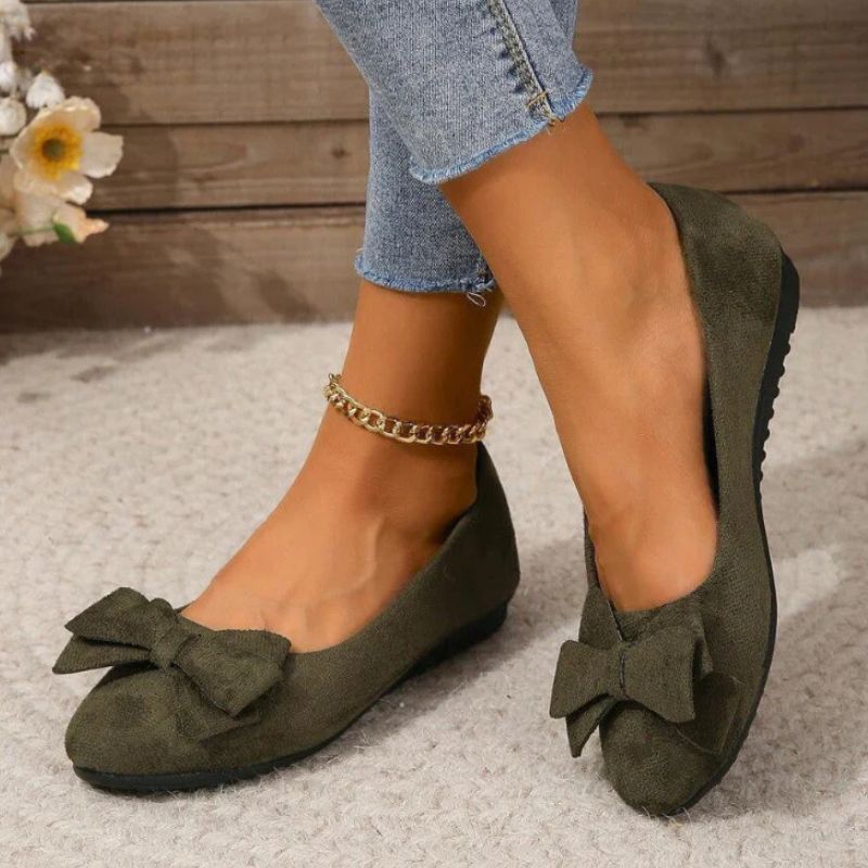 Wide fit cushioned ballet flats in dark green faux suede with bow, worn with denim