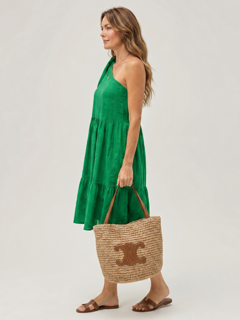 Green one-shoulder knee-length dress with bow strap and tiered skirt, side view