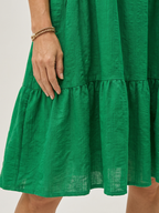 Green tiered knee-length dress with textured fabric and ruffled tier hems