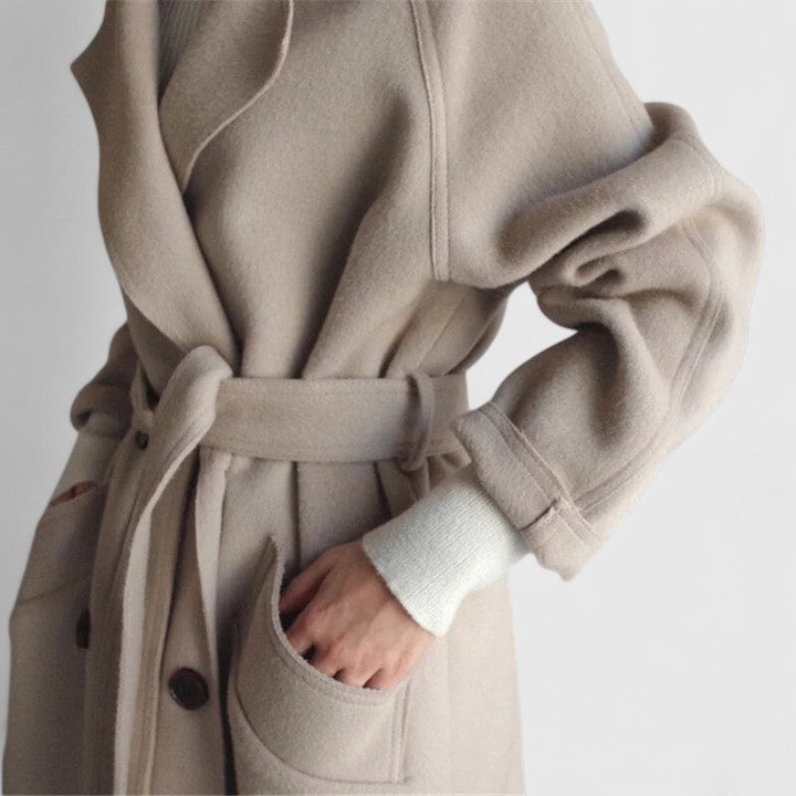 Beige belted coat close-up with tie waist, front pockets, and button placket