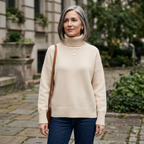 Beige ribbed knit turtleneck sweater worn with dark blue jeans